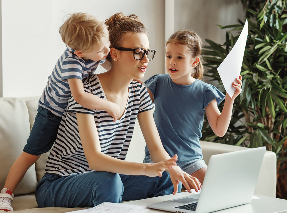 mother with 2 children working on a laptop