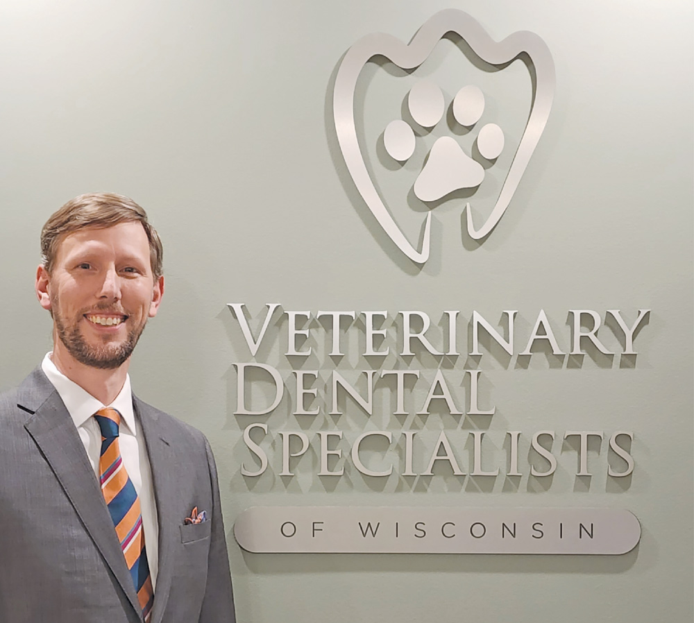 Dr. Steven Honzelka next to a Veterinary Dental Specialists of Wisconsin sign