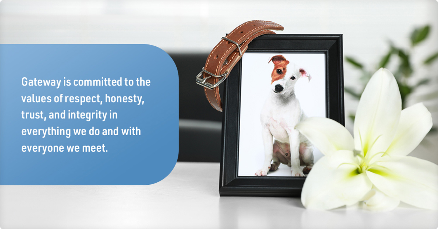 banner that reads: Gateway is committed to the values of respect, honesty, trust, and integrity in everything we do and with everyone we meet beside a memorial framed picture of a dog with a collar hanging on a corner of the frame and a flower resting beside the frame