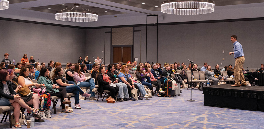 people seated at a presentation in a ballroom